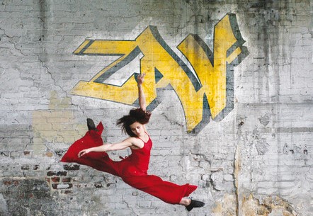 Das Bild zeigt eine springende Tänzerin im roten kleid